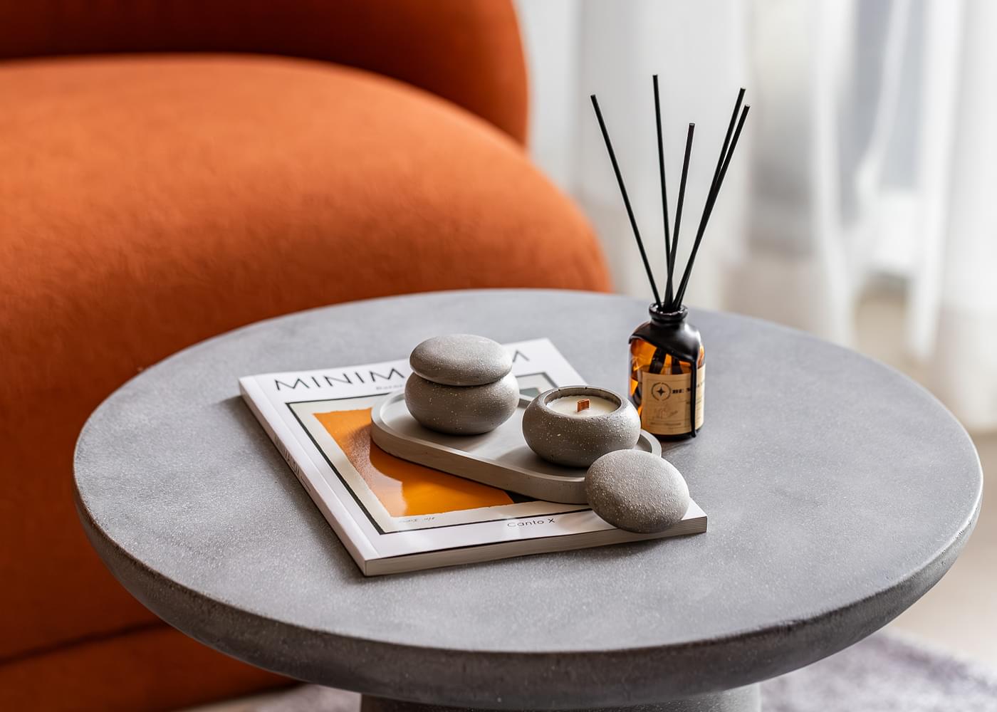 A round table featuring a magazine, a candle, and a book, highlighting a stylish interior from TaskForce's Dubai Marina project.