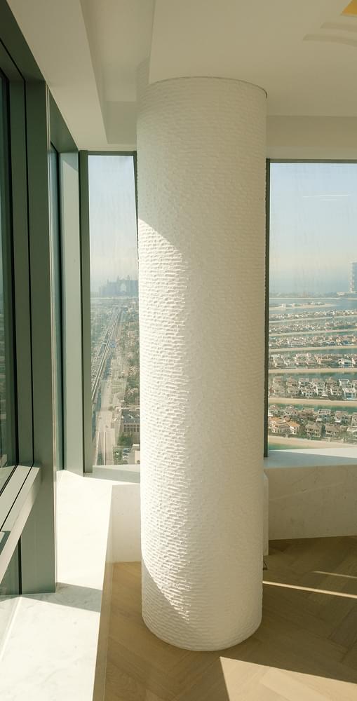 Interior view of a tall white pillar with a city skyline backdrop, part of TaskForce's renovation project in Dubai.