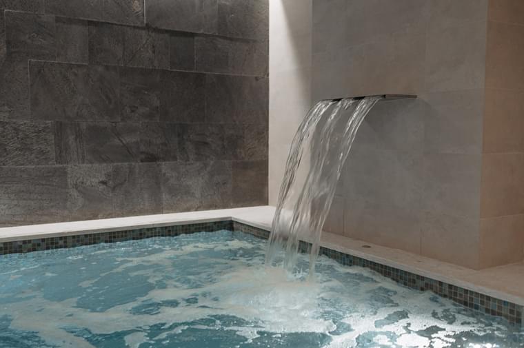 A serene swimming pool featuring a cascading waterfall.